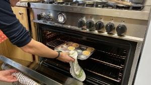 kitchen facilities - muffin tray being removed from a oven