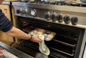 kitchen facilities - muffin tray being removed from a oven